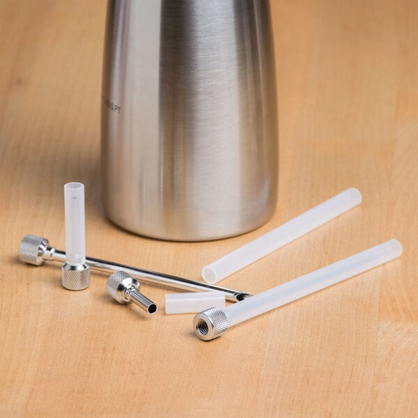 A stainless steel iSi injector tip with white plastic strips inside.