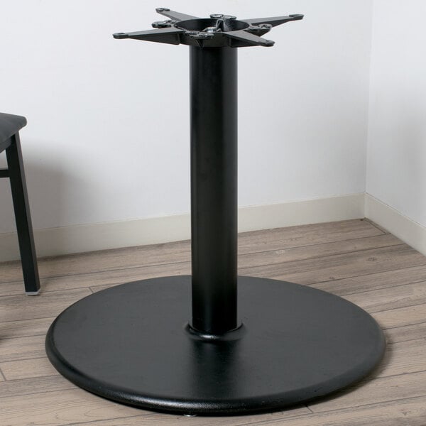 Black steel table base with round base on wood floor