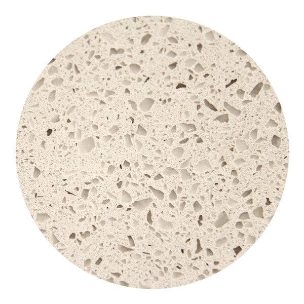 A close up of a white Art Marble Furniture round quartz tabletop with small holes.