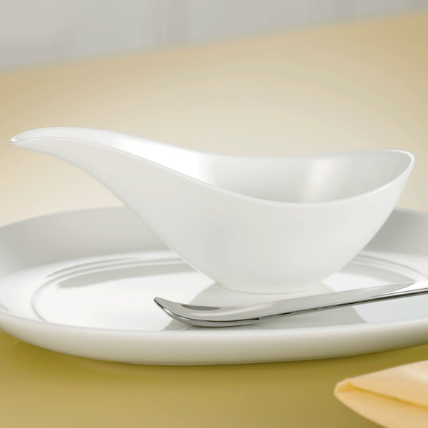 A white bowl on a white plate with a Villeroy & Boch white sauceboat on it.