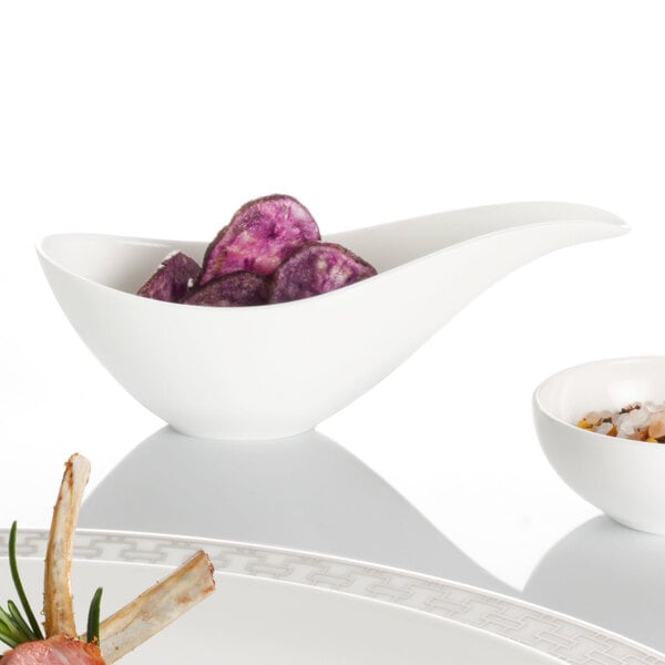 A white bowl with white sauce in it.