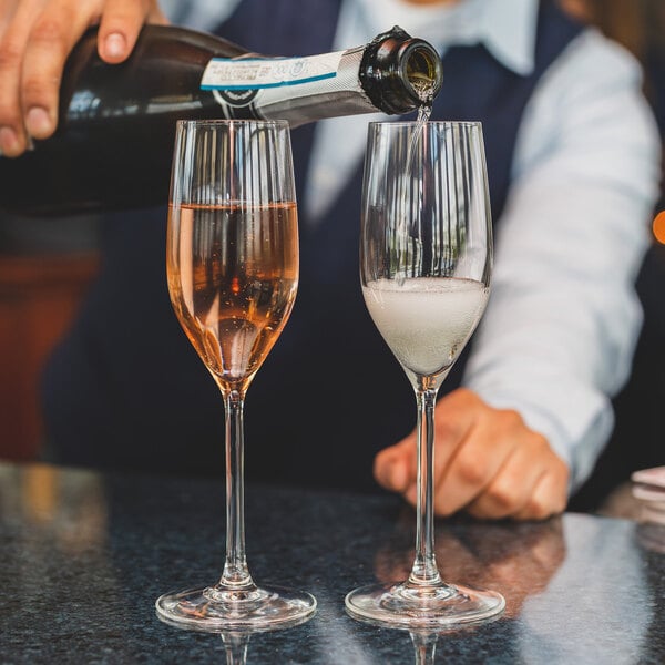 A person pouring wine into two Chef & Sommelier Sequence wine glasses.