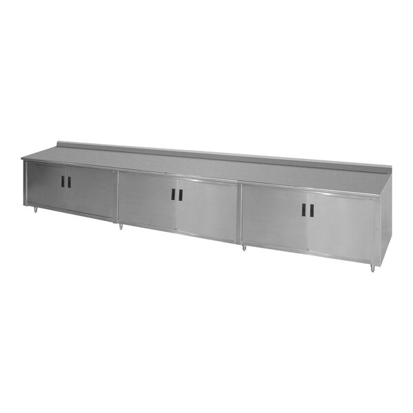 An Advance Tabco stainless steel work table with a fixed midshelf and backsplash.