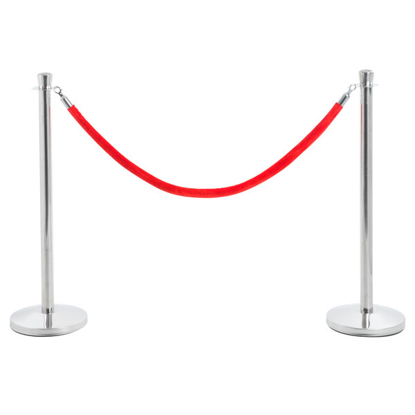A Lancaster Table & Seating silver rope-style crowd control stanchion with red rope wrapped around it.