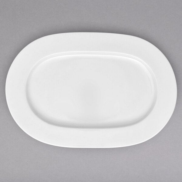 A white bone porcelain oval platter with a white rim.