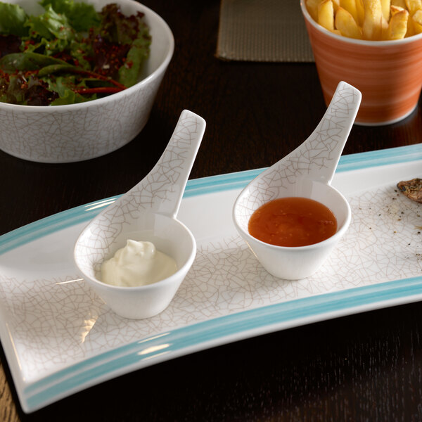 A plate with a bowl of fries and a bowl of sauce.