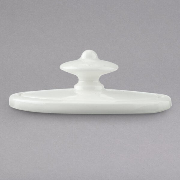 A close-up of a white porcelain Villeroy & Boch coffeepot lid with a white plastic knob.