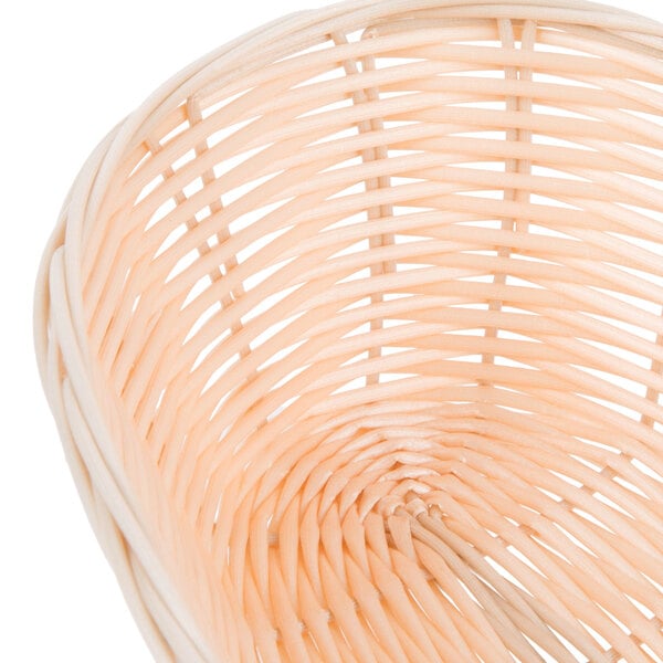 A close up of a Tablecraft rattan-like bread basket.