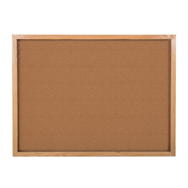 A wooden cork board with a natural oak frame.