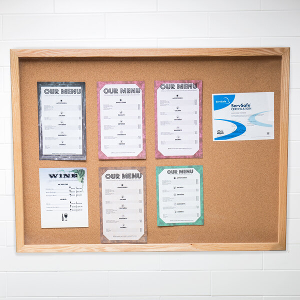 An Aarco enclosed cork bulletin board with menus on it.