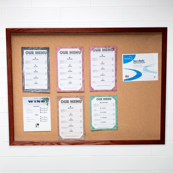 An Aarco enclosed cork bulletin board with a cherry finish.