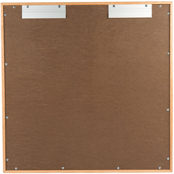 An Aarco natural oak enclosed bulletin board with metal clips.
