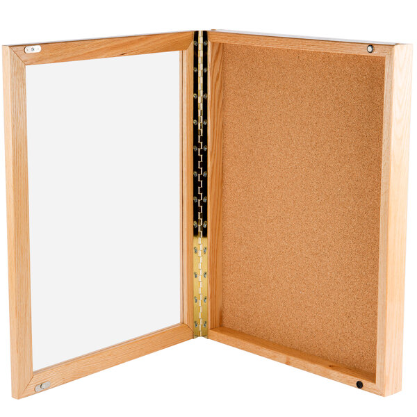 An Aarco enclosed bulletin board with a wooden frame.