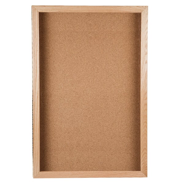 An Aarco natural oak enclosed cork board with a wooden frame.