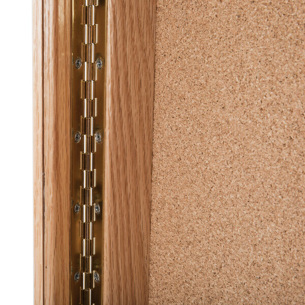 The hinged door of a natural oak rectangular display case.