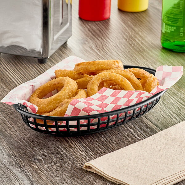 A black plastic oval fast food basket filled with fried onion rings.