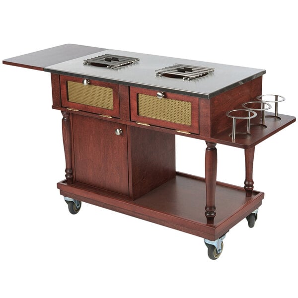 A Bon Chef mahogany and metal flambe trolley with burners on a wood counter.