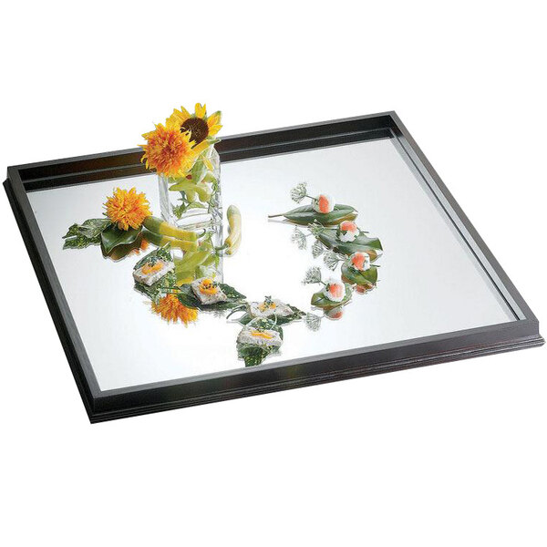 A Bon Chef wood frame mirror tray with a glass jar of flowers on it.