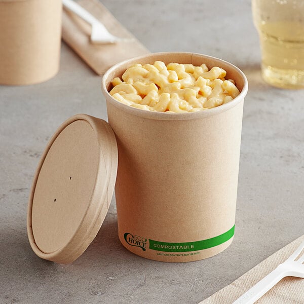 A Kraft paper food cup with macaroni and cheese and a fork on a napkin.