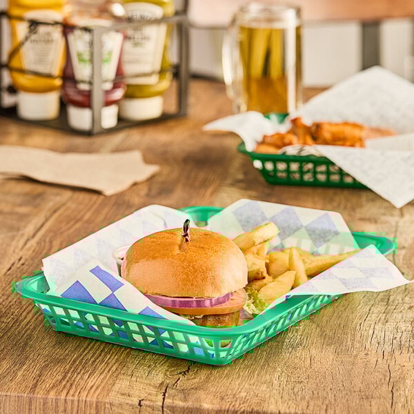 A green rectangular plastic fast food basket with a burger and fries in it.