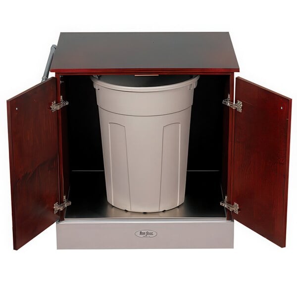 A white Bon Chef rectangular mobile waste cart inside a wood cabinet.