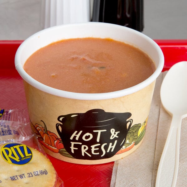 A tray with a bowl of soup and a spoon on it.