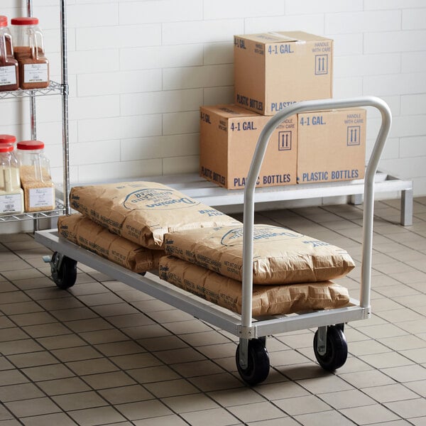 A Regency mobile aluminum dunnage rack with bags of food on it.