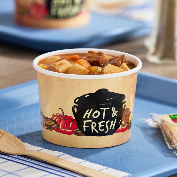 A Choice paper soup cup filled with meat and vegetable soup on a tray.