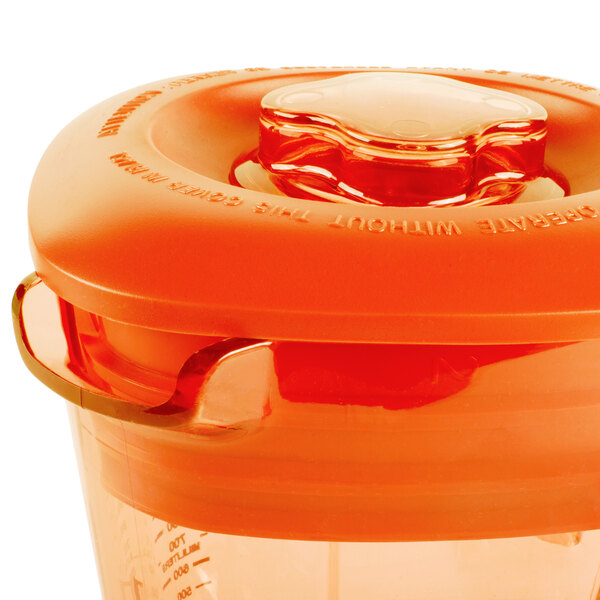 A Waring orange plastic blender jar with a lid.