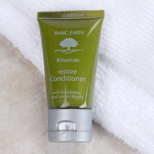A case of 300 green Basic Earth Botanicals Restoring Conditioner bottles with white text and flip-top caps.