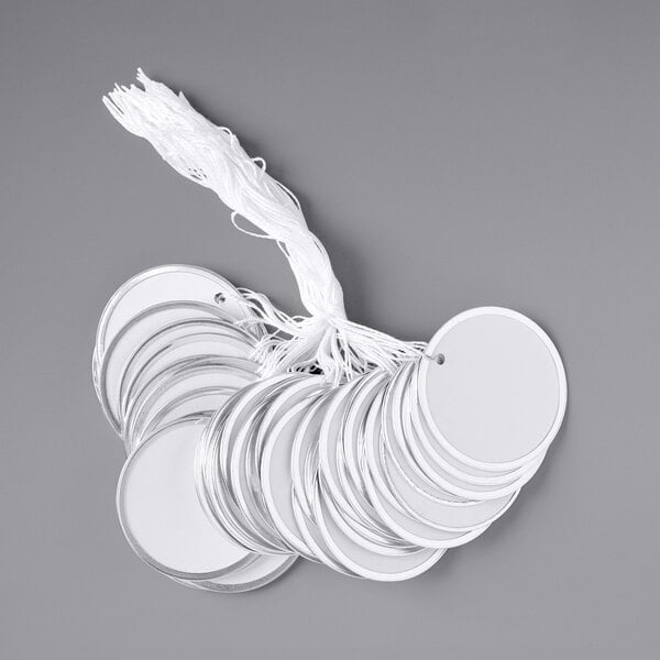 A group of round white metal rim tags with a string.