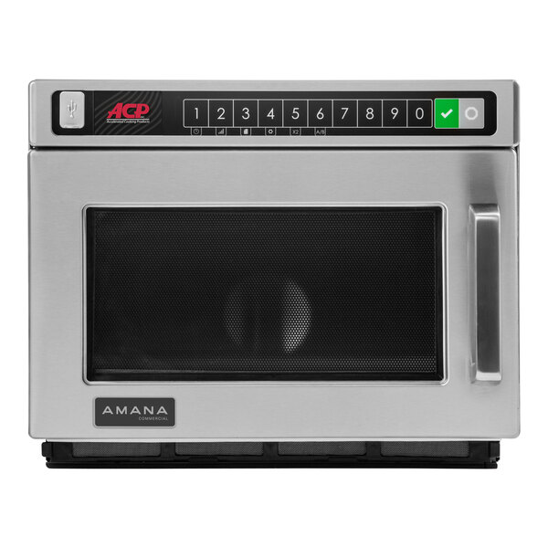 An Amana stainless steel commercial microwave with a black door.