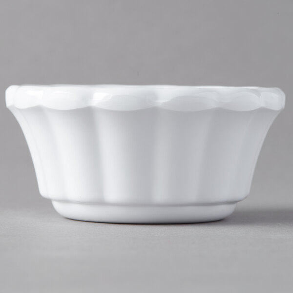 A white Carlisle scalloped ramekin on a gray surface.