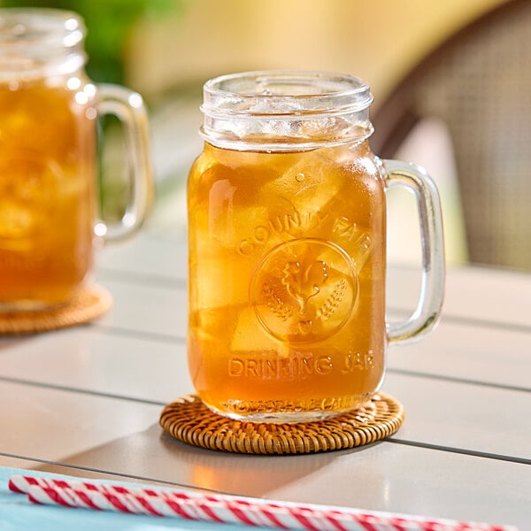 Two Libbey County Fair mason jars filled with iced tea on a table.