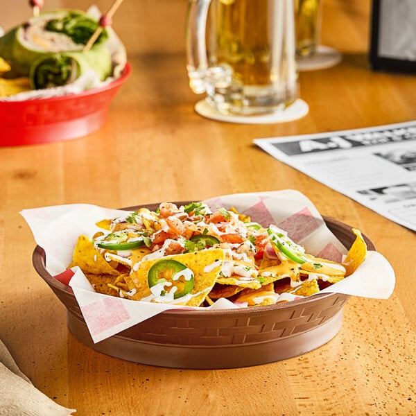 A brown plastic diner platter holding a bowl of nachos with salsa, jalapenos, and cheese on a table.