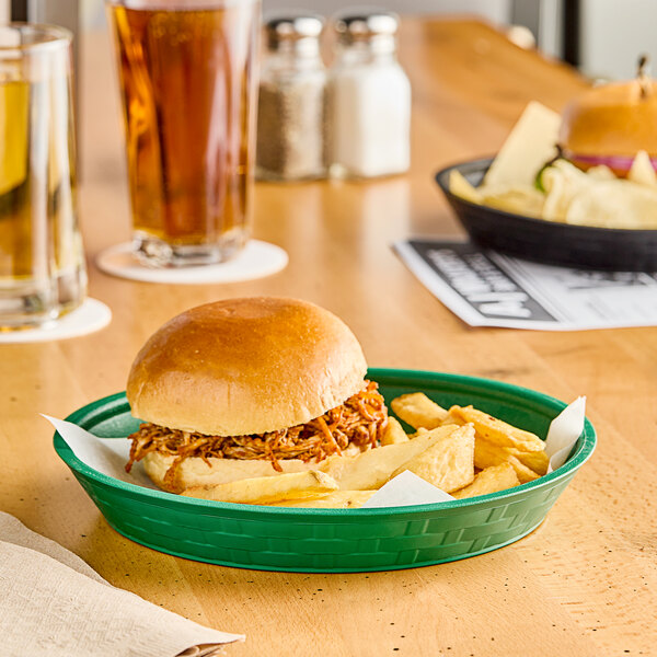 A green Choice plastic diner platter with a sandwich and fries.