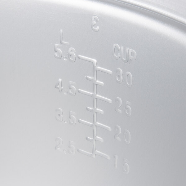 A Town rice cooker measuring cup on a white surface.