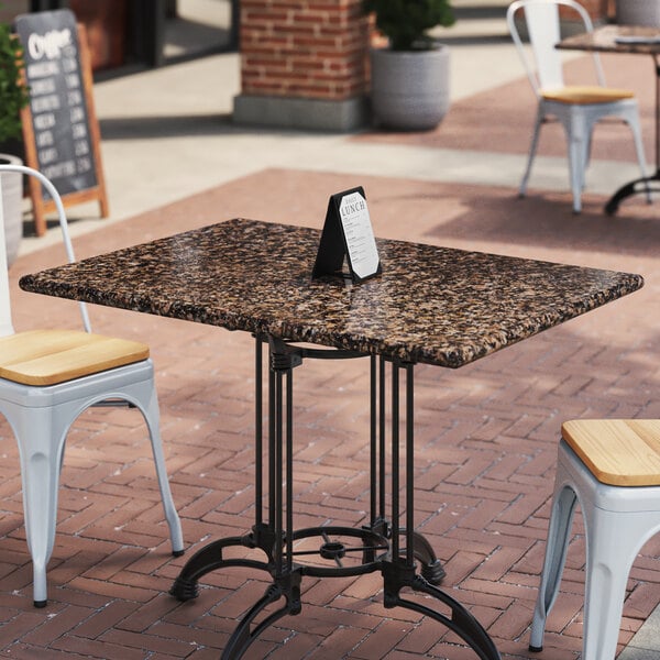 A table with a tan brown granite top on an outdoor patio.