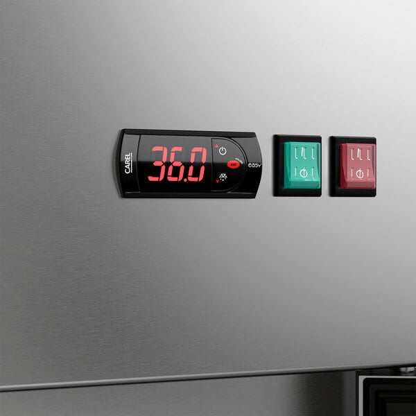 A stainless steel reach-in refrigerator with a digital temperature display and control panel featuring green and red power switches.