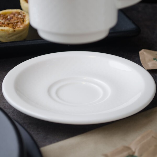 A white plate with a white porcelain saucer on it.