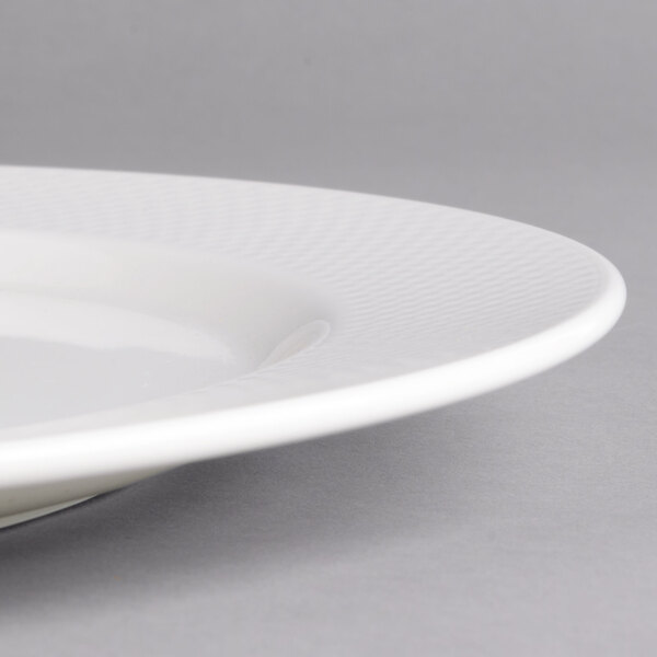 A close-up of a Villeroy & Boch white porcelain flat plate with a thin rim.