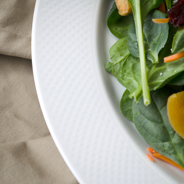 A Villeroy & Boch white porcelain round platter with salad including orange slices and greens.