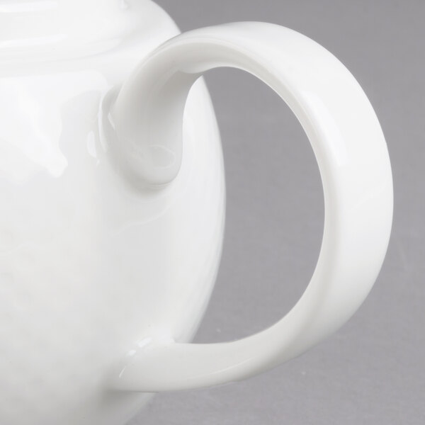 A white Villeroy & Boch porcelain teapot with a handle.