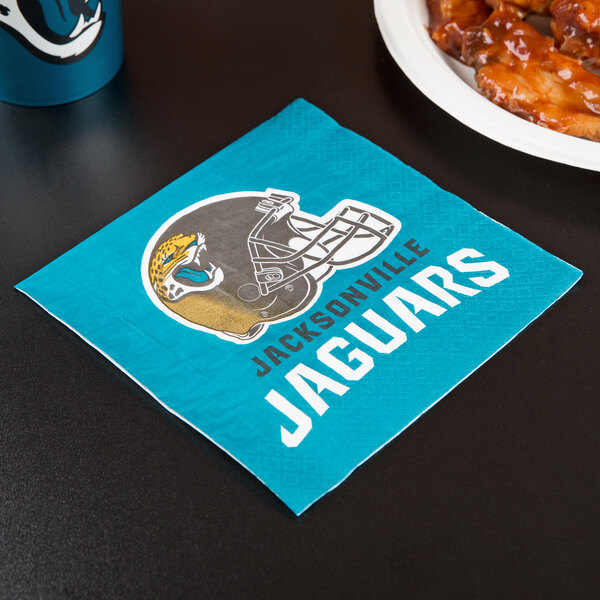 A blue napkin with a Jacksonville Jaguars football helmet logo next to a plate of chicken wings.