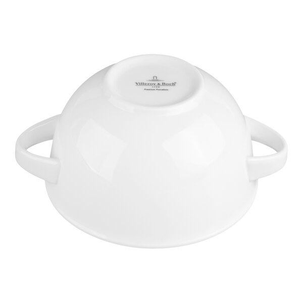 A white porcelain bowl with two handles, shown upside down on a white background.