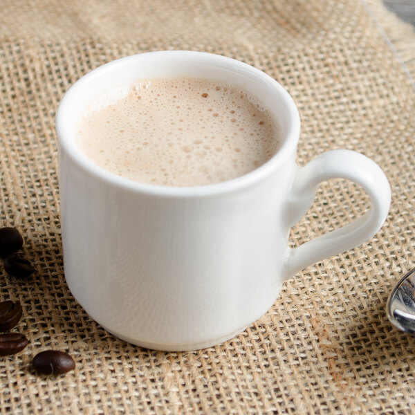 A white Villeroy & Boch porcelain stackable cup of coffee with a spoon.