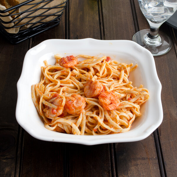 A Villeroy & Boch white porcelain square salad bowl filled with pasta and shrimp.