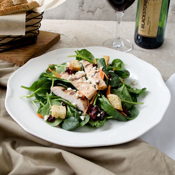A Villeroy & Boch white porcelain round platter with a salad of grilled chicken and croutons.