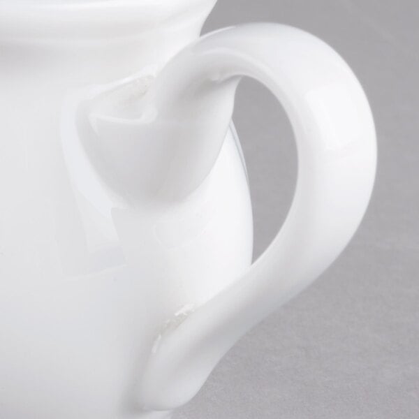 A white Villeroy & Boch porcelain creamer with a handle.