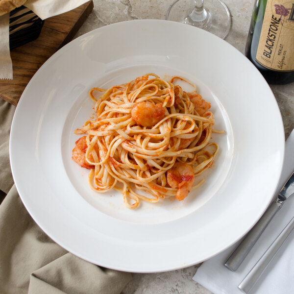 A white Villeroy & Boch porcelain plate with pasta and shrimp on it.